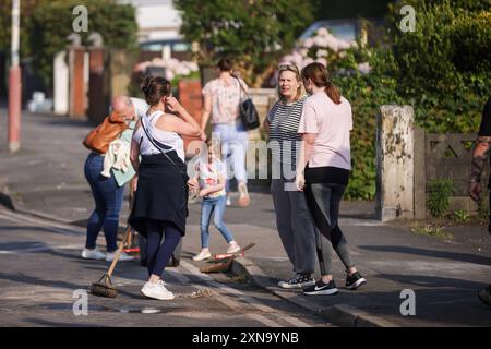 I volontari perlustrano Sussex Road a Southport, Merseyside, dopo che gli agenti di polizia hanno subito gravi lesioni quando mattoni, pietre e bottiglie sono state gettate e le auto sono state accese durante le proteste violente a seguito di una veglia per tre ragazze uccise in un attacco con coltello in un club di vacanza a tema Taylor Swift lunedì. Data foto: Mercoledì 31 luglio 2024. Foto Stock