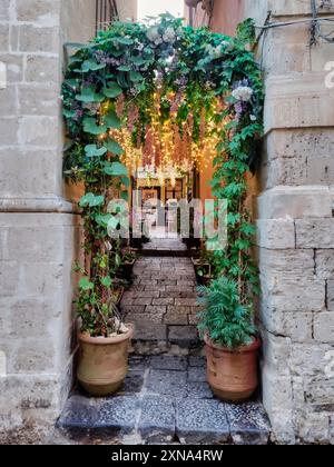Ingresso di un accogliente ristorante in un vicolo stretto di Ortigia, centro storico di Siracusa Foto Stock