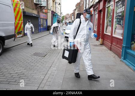 Gli investigatori forensi della polizia entrano in un edificio in disuso a Fore Bondgate, Bishop Auckland, nella contea di Durham, dopo che uno scheletro di un bambino è stato trovato sotto le tavole da pavimento da appaltatori che lavorano alla ristrutturazione di una proprietà. Data foto: Mercoledì 31 luglio 2024. Foto Stock