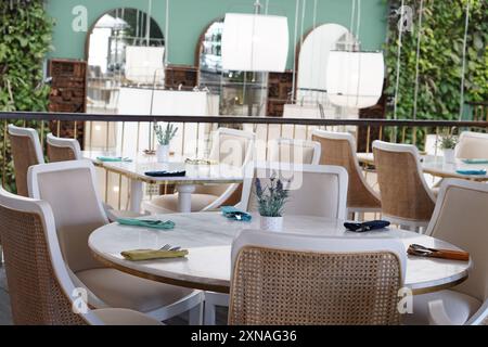 un ristorante interno moderno ed elegante con tavoli in marmo bianco Foto Stock