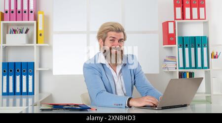 Happy Business man che lavora con pile di documenti cartacei. Ricerca di informazioni. Documenti di report e pile di documenti ottenuti sulla scrivania del computer portatile Foto Stock
