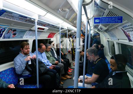 Persone che viaggiano su un affollato vagone della metropolitana di Londra. Londra, Regno Unito, 7 luglio 2024. Foto Stock