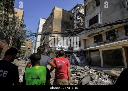 Beirut, Libano. 31 luglio 2024. I lavoratori della difesa civile ispezionano la distruzione in edifici che sono stati presi di mira da un drone israeliano nel sobborgo meridionale di Beirut. 4 persone furono uccise e ferirono più di 70 persone. L'esercito israeliano ha dichiarato martedì di aver effettuato un "attacco mirato” contro un comandante della milizia filo-iraniana di Beirut. L'esplosione è avvenuta tre giorni dopo un attacco missilistico mortale alle alture del Golan occupate da Israele. Crediti: Marwan Naamani/dpa/Alamy Live News Foto Stock