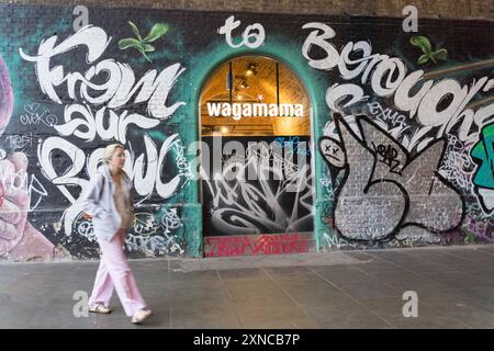 Insegna di Wagamama stampata sulla vetrina del fast food Wagamama, con pareti esterne dipinte dalla ciotola al ristorante Borough's Eats Londra Inghilterra Regno Unito Foto Stock