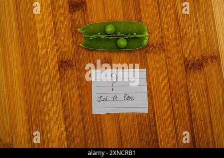 Due peperoncini organici in una capsula aperta su uno sfondo di legno e una nota che dice in una capsula Foto Stock