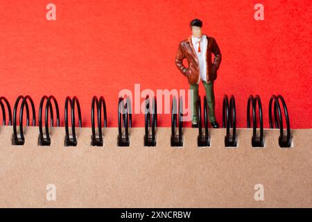 Figura accanto al notebook a spirale Foto Stock