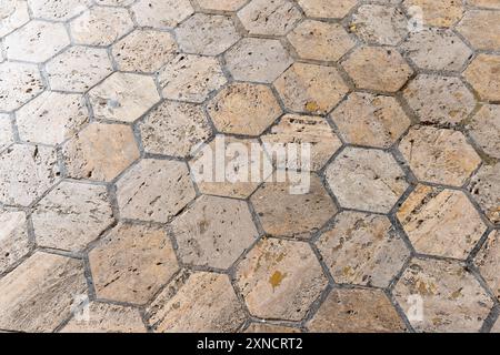 Vecchio pavimento in pietra realizzato con piastrelle esagonali beige, texture fotografica di sfondo Foto Stock