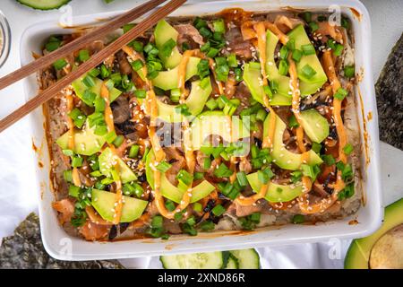 Philadelphia Sushi Bake ricetta casseruola a base di riso, formaggio cremoso, trota di salmone, alghe, avocado, salsa, cipolla verde. Servito con nori di canna tostata Foto Stock