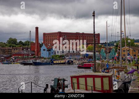 Barche ormeggiate a Underfall Yard, Bristol Harbour durante il festival del 2024, con un vecchio magazzino vittoriano sullo sfondo, l'Inghilterra. Foto Stock