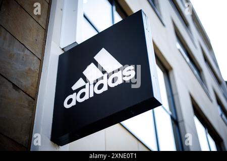 30 luglio 2024, Baviera, Norimberga: Il logo del produttore di articoli sportivi Adidas è visibile sulla facciata di un negozio di abbigliamento sportivo del marchio, un cosiddetto negozio Adidas, nel centro di Norimberga (Baviera) il 30 luglio 2024. Adidas AG è un'azienda tedesca produttrice di articoli sportivi attiva a livello internazionale con sede a Herzogenaurach, vicino a Norimberga. L'azienda offre abbigliamento, scarpe, attrezzature sportive, accessori e prodotti in licenza come orologi, cosmetici e occhiali in tutto il mondo attraverso i propri negozi e punti vendita. Il logo Adidas con le tre strisce parallele è uno dei più noti Foto Stock