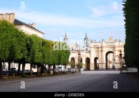 Sole al Grand Hotel in piazza Stanislas, chiuso da un cancello dorato in ferro battuto con la cattedrale di Nancy sullo sfondo. Foto Stock