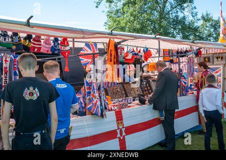 Ballyclare, Irlanda del Nord - 27 agosto 2022: Detentore dello stallo che vende cimeli lealisti dell'Ulster, cappelli e bandiere. Mercato concettuale, venditore, commercio. Foto Stock