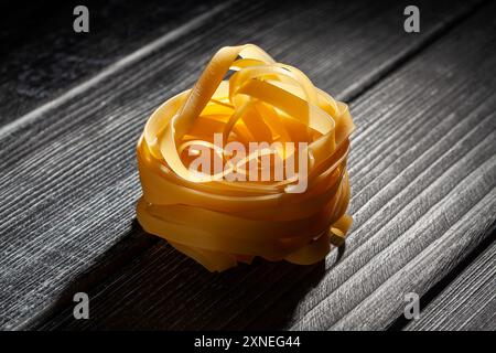 tagliatelle di pasta su fondo in legno Foto Stock
