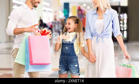 Happy Young Girl riceve un regalo dal padre durante lo shopping Foto Stock