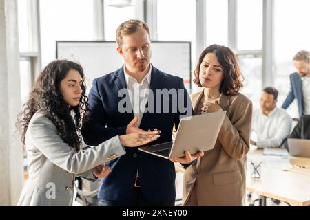 Professionisti aziendali che discutono di Project on laptop in Modern Office Foto Stock