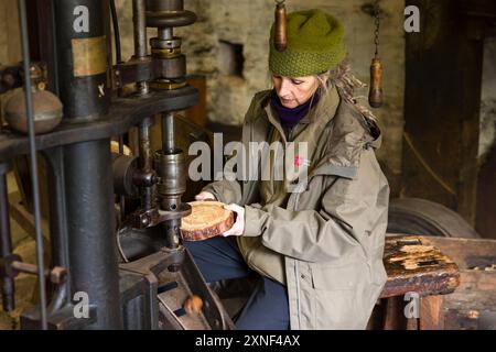 CUMBRIA, Regno Unito - 25 aprile 2024. Donna che mostra macchinari al museo di lavoro Stott Park Bobbin Mill nel Lake District, Regno Unito Foto Stock