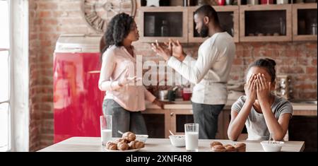 Ragazza Litttle gridando in cucina come genitori combattimenti Foto Stock