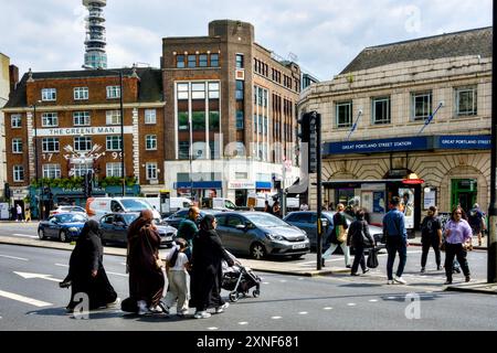 People Crossing the Road di fronte alla stazione di Great Portland Street, Euston Road, Borough of Camden, Londra, Inghilterra, REGNO UNITO Foto Stock