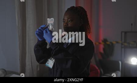 La detective afroamericana analizza le prove sulla scena del crimine al chiuso si è concentrata sul serio Foto Stock