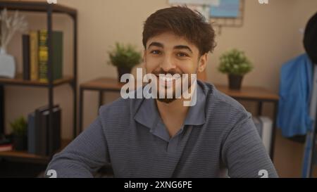 Bell'arabo con barba sorridente nel moderno soggiorno dell'appartamento Foto Stock