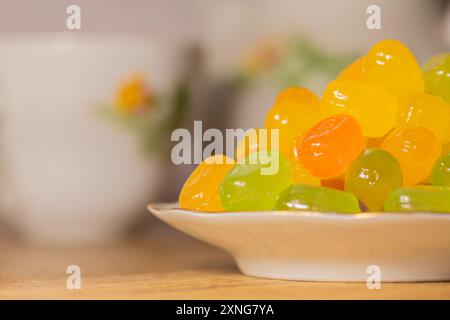 Caramelle dure colorate su un piattino. Piattino con caramelle dolci alla frutta colorata assortite su un tavolo di legno, primo piano, ad alta risoluzione. Foto Stock