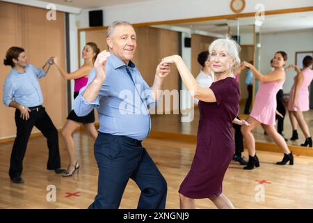 Allegra coppia anziana che pratica danze da ballo nella sala da ballo Foto Stock