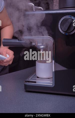 Woman Barista gestisce una macchina per preparare un caffè delizioso, primo piano di mani utilizzando la macchina per il caffè espresso. Foto Stock