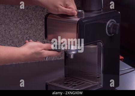 Woman Barista gestisce una macchina per preparare un caffè delizioso, primo piano di mani utilizzando la macchina per il caffè espresso. Foto Stock