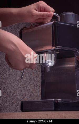 Woman Barista gestisce una macchina per preparare un caffè delizioso, primo piano di mani utilizzando la macchina per il caffè espresso. Foto Stock