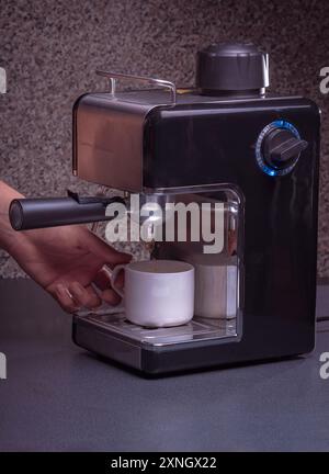 Woman Barista gestisce una macchina per preparare un caffè delizioso, primo piano di mani utilizzando la macchina per il caffè espresso. Foto Stock