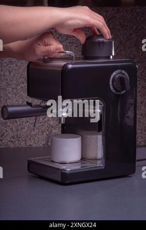 Woman Barista gestisce una macchina per preparare un caffè delizioso, primo piano di mani utilizzando la macchina per il caffè espresso. Foto Stock