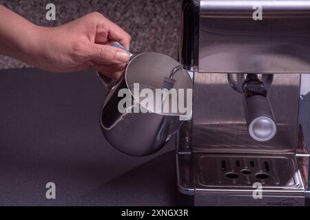 Woman Barista gestisce una macchina per preparare un caffè delizioso, primo piano di mani utilizzando la macchina per il caffè espresso. Foto Stock