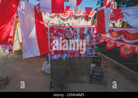 Balikpapan, Indonesia - 29 luglio 2024. Un venditore ambulante che mostra la colorata esposizione di bandiere e decorazioni indonesiane. Foto Stock