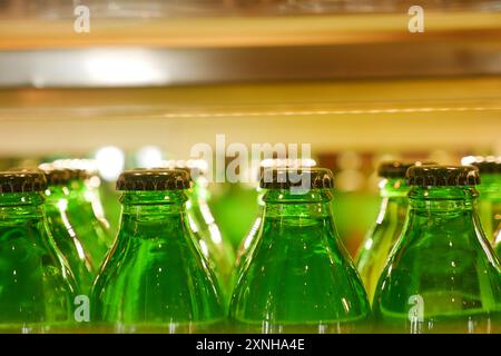 Le bottiglie per bevande vintage con tappi colorati sullo scaffale del bar creano un'atmosfera retrò nostalgica Foto Stock