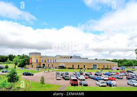 Il British Motor Museum Gaydon è l'ingresso principale e l'area di ricevimento contro il cielo blu e le nuvole bianche Foto Stock