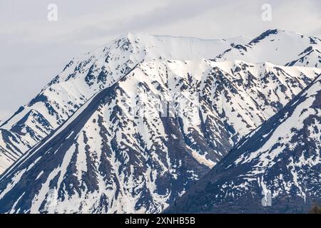 Splendida vista sul lago Kathleen nel territorio dello Yukon, Canada settentrionale, con un lago tranquillo e incontaminato sotto le vette innevate, maggio. Foto Stock