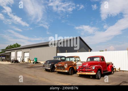 Tre vecchi pick-up Chevrolet inoperabili degli anni '1950 siedono di fronte a un'azienda a Huntington, Indiana, USA. Foto Stock