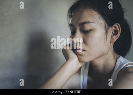 Giovane donna che soffre di depressione e ansia seduta sul pavimento. La donna si sente frustrata e confusa, infelice, problemi personali, stress. Foto Stock