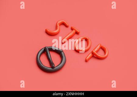 Parola rossa STOP con segno di pasta da gioco su sfondo rosso Foto Stock