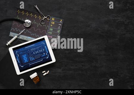 Tablet computer e forniture mediche su sfondo scuro. Concetto di telemedicina Foto Stock