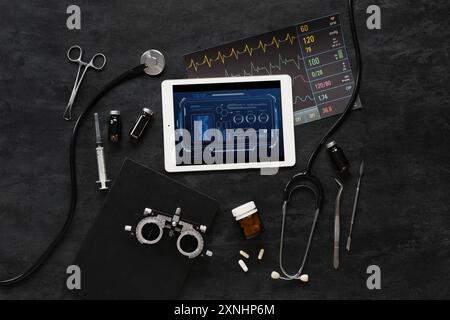 Tablet computer e forniture mediche su sfondo scuro. Concetto di telemedicina Foto Stock