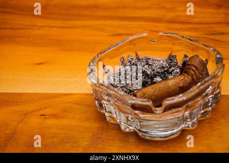 Sigaro nel posacenere sul tavolo di legno vista ravvicinata Foto Stock