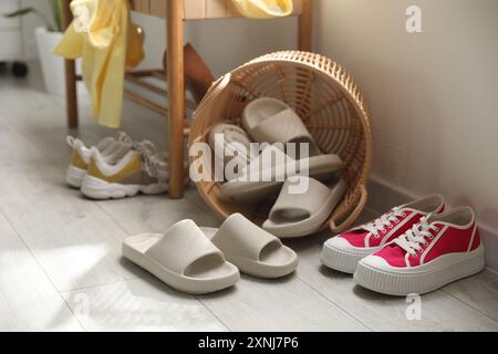 Cestino con pantofole per gli ospiti e scarpe da ginnastica all'ingresso di casa Foto Stock