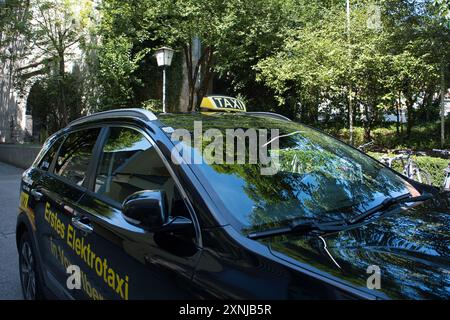 Un taxi nero con un cartello giallo sul tetto. Il taxi è parcheggiato in un parcheggio Foto Stock