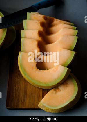 melone tagliato a fette su un tagliere Foto Stock