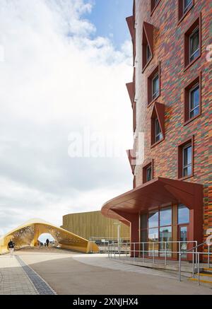 Giustapposizione di facciate. Swansea Arena e Copr Bay Bridge, Swansea, Regno Unito. Architetto: acme, 2024. Foto Stock