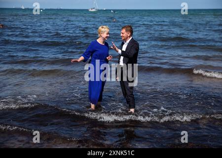 Rostock, Germania. 1 agosto 2024. Manuela Schwesig (SPD), Ministro Presidente del Meclemburgo-Pomerania occidentale, e il suo omologo sassone Michael Kretschmer (CDU) si trovano sulla spiaggia nelle acque del Mar Baltico. I due governi statali firmano un accordo per migliorare la cooperazione nel settore del turismo. Crediti: Jens Büttner/dpa/Alamy Live News Foto Stock