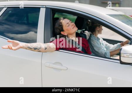 Due amiche che guidano in macchina e si divertono in vacanza. Foto Stock