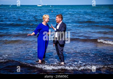 Rostock, Germania. 1 agosto 2024. Manuela Schwesig (SPD), Ministro Presidente del Meclemburgo-Pomerania occidentale, e il suo omologo sassone Michael Kretschmer (CDU) si trovano sulla spiaggia nelle acque del Mar Baltico. I due governi statali firmano un accordo per migliorare la cooperazione nel settore del turismo. Crediti: Jens Büttner/dpa/Alamy Live News Foto Stock