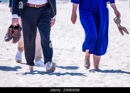 Rostock, Germania. 1 agosto 2024. Manuela Schwesig (SPD), ministro presidente del Meclemburgo-Pomerania occidentale, e il suo omologo sassone Michael Kretschmer (CDU) camminano a piedi nudi sulla spiaggia del Mar Baltico. I due governi statali firmano un accordo per migliorare la cooperazione nel settore del turismo. Crediti: Jens Büttner/dpa/Alamy Live News Foto Stock